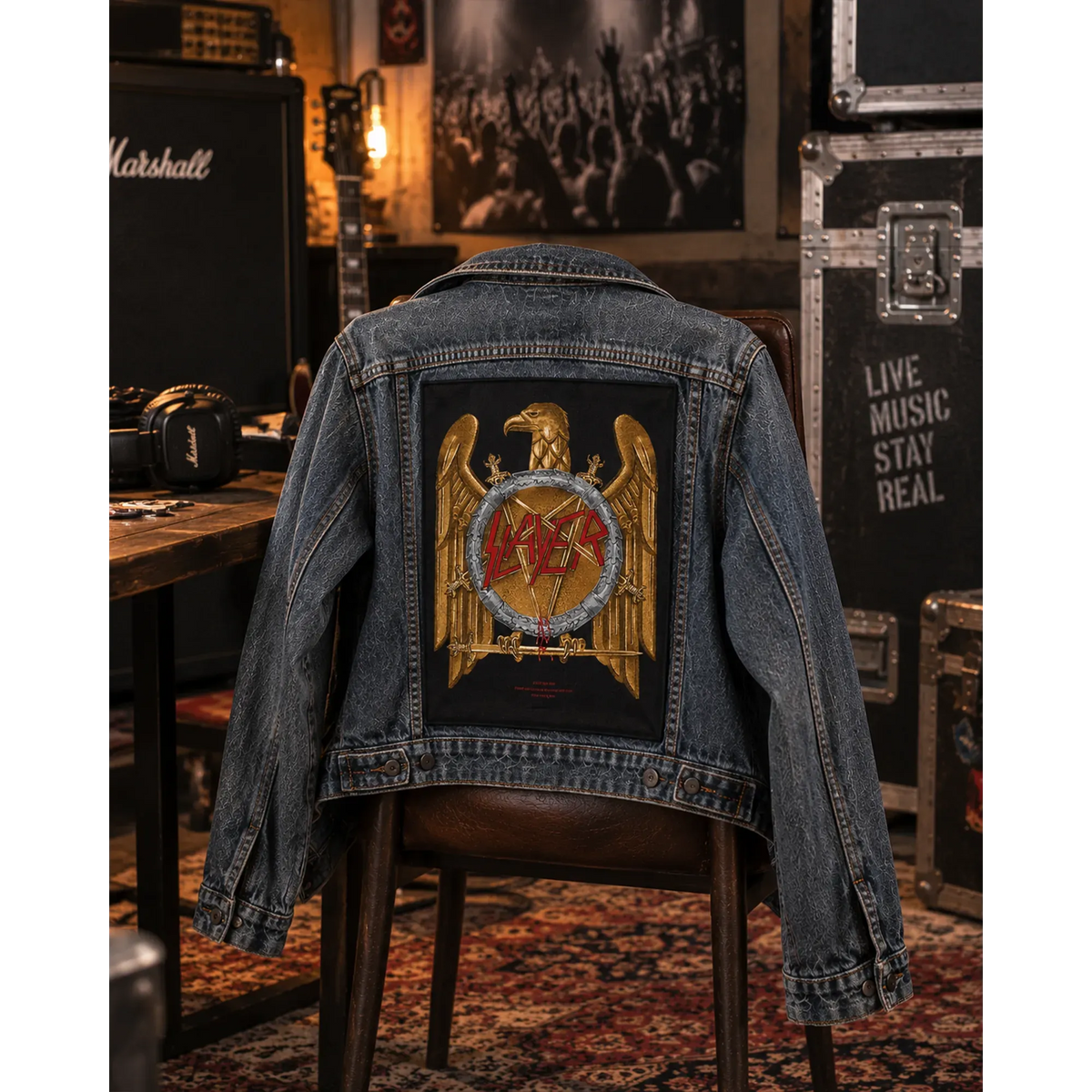 Backpatch Slayer avec aigle doré sur veste en jean posée sur une chaise | Slayer golden eagle backpatch on a denim jacket draped over a chair