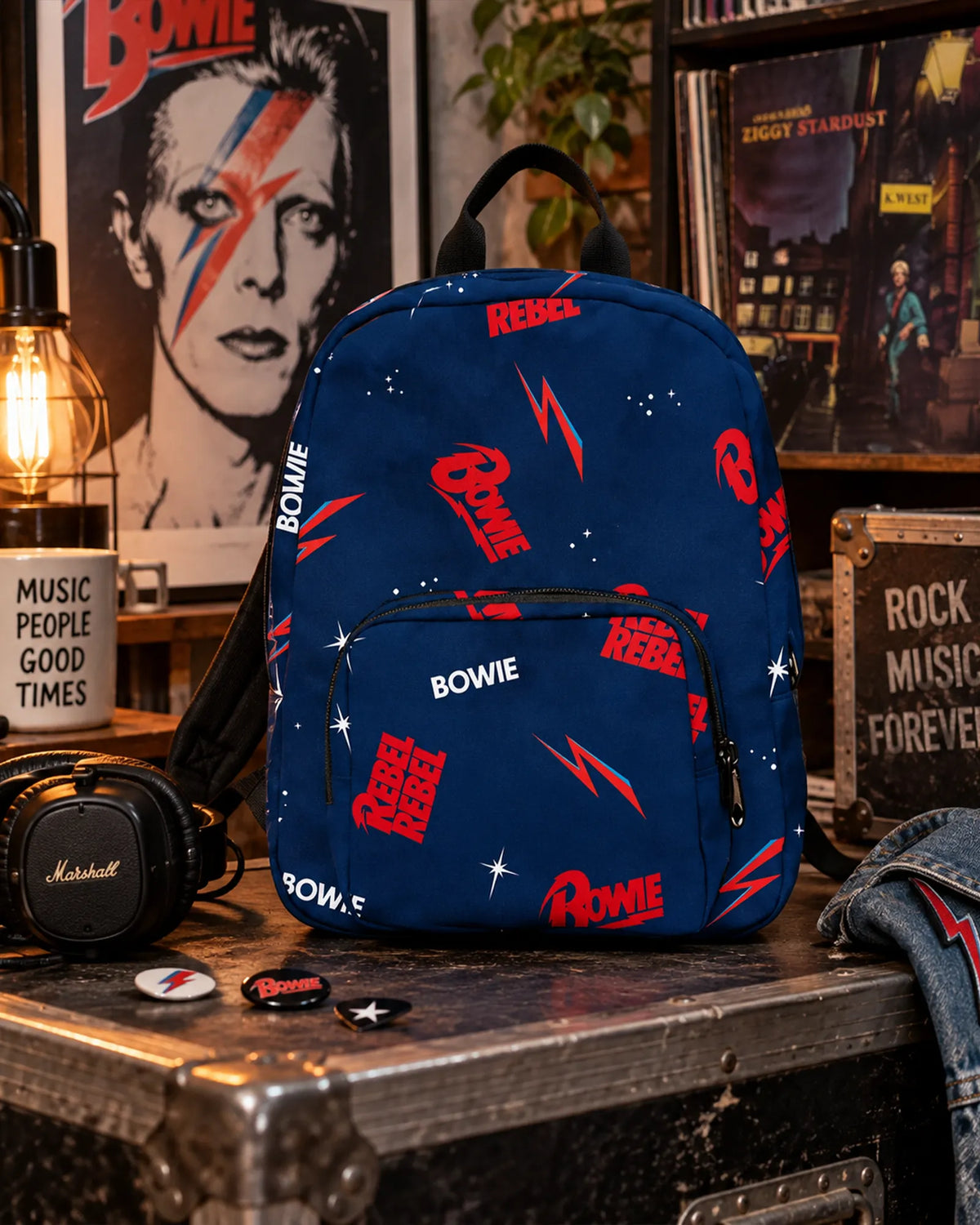 Mini sac à dos David Bowie Rebel Rebel bleu avec logos rouges, éclairs et étoiles en décor urbain | David Bowie Rebel Rebel blue mini backpack with red logos, lightning bolts and stars in an urban setting