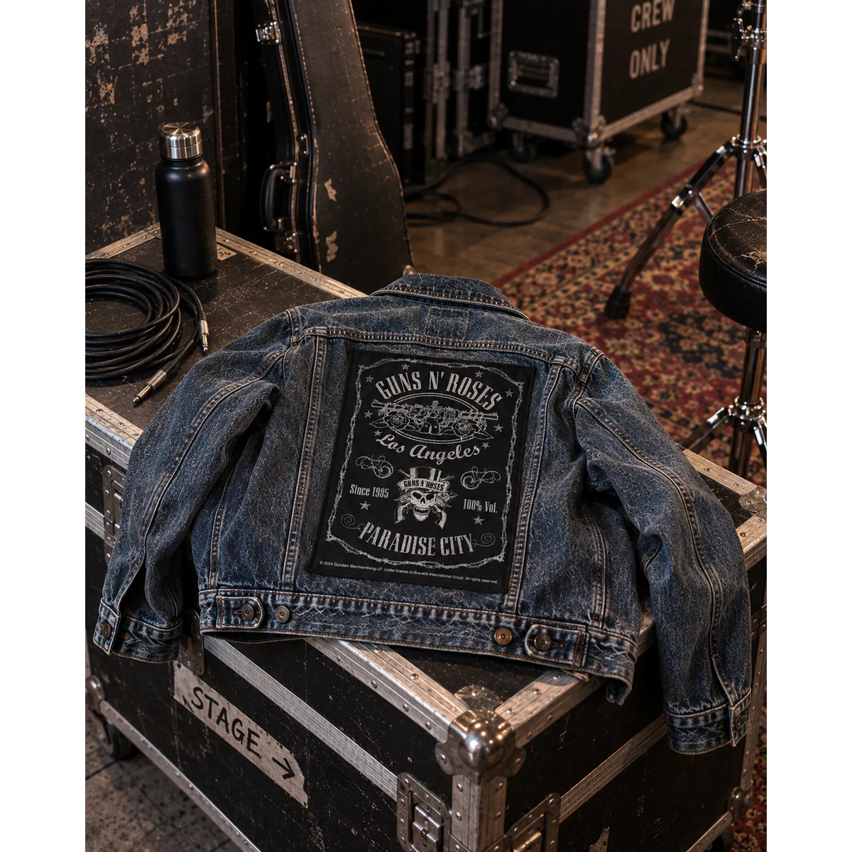 Backpatch Guns N' Roses Paradise City sur veste en jean posée sur un flight case | Guns N' Roses Paradise City backpatch on a denim jacket laid over a flight case