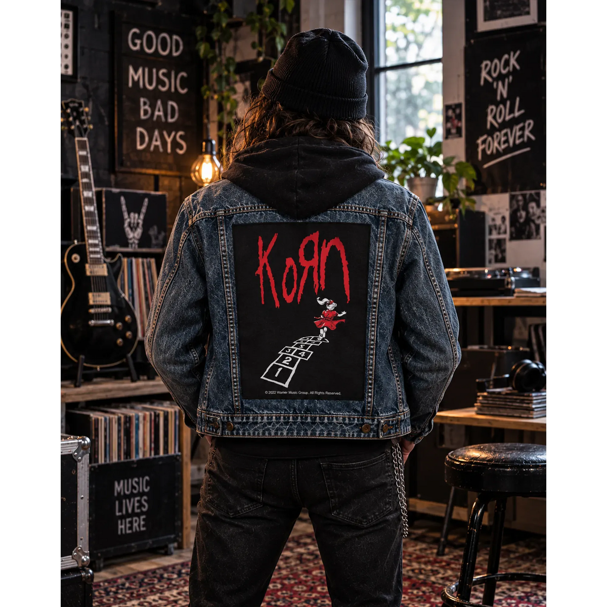 Backpatch Korn follow the leader noir et rouge porté au dos d'une veste en jean dans un intérieur rock | Black and red Korn follow the leader backpatch worn on a denim jacket in a rock-themed room