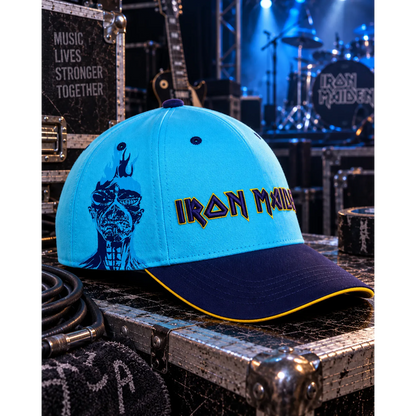 Casquette Iron Maiden seventh son of a seventh son bleue ciel avec portrait d’Eddie et logo brodé, ambiance de scène bleutée | Sky blue Iron Maiden seventh son of a seventh son cap with Eddie portrait and embroidered logo in a blue-lit stage setting