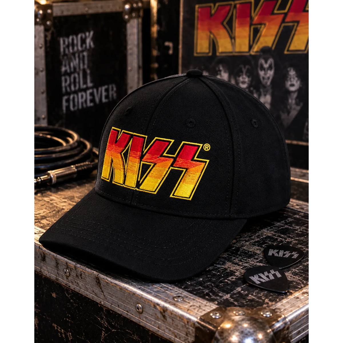 Casquette KISS noire avec logo brodé rouge, orange et jaune dans un décor backstage rock | Black KISS cap with red, orange and yellow embroidered logo in a rock backstage setting
