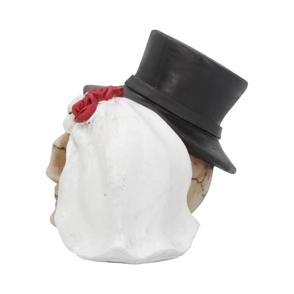 Vue de 3/4 arrière de la figurine gothique – focus sur le voile blanc du crâne féminin et chapeau du crâne masculin