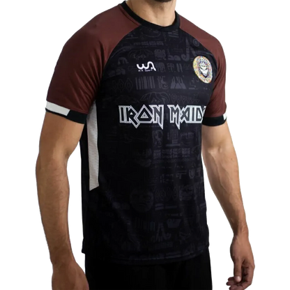 Maillot de football officiel Iron Maiden The Book Of Souls – vue de face, noir et marron avec écusson Maiden FC | Official Iron Maiden The Book Of Souls football shirt – front view, black and brown with Maiden FC badge