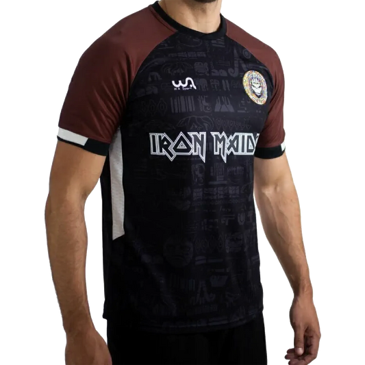 Maillot de football officiel Iron Maiden The Book Of Souls – vue de face, noir et marron avec écusson Maiden FC | Official Iron Maiden The Book Of Souls football shirt – front view, black and brown with Maiden FC badge