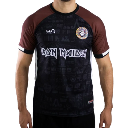 Maillot de football officiel Iron Maiden The Book Of Souls – vue de face, noir et marron avec écusson Maiden FC | Official Iron Maiden The Book Of Souls football shirt – front view, black and brown with Maiden FC badge