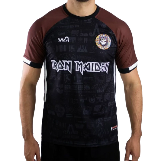 Maillot de football officiel Iron Maiden The Book Of Souls – vue de face, noir et marron avec écusson Maiden FC | Official Iron Maiden The Book Of Souls football shirt – front view, black and brown with Maiden FC badge